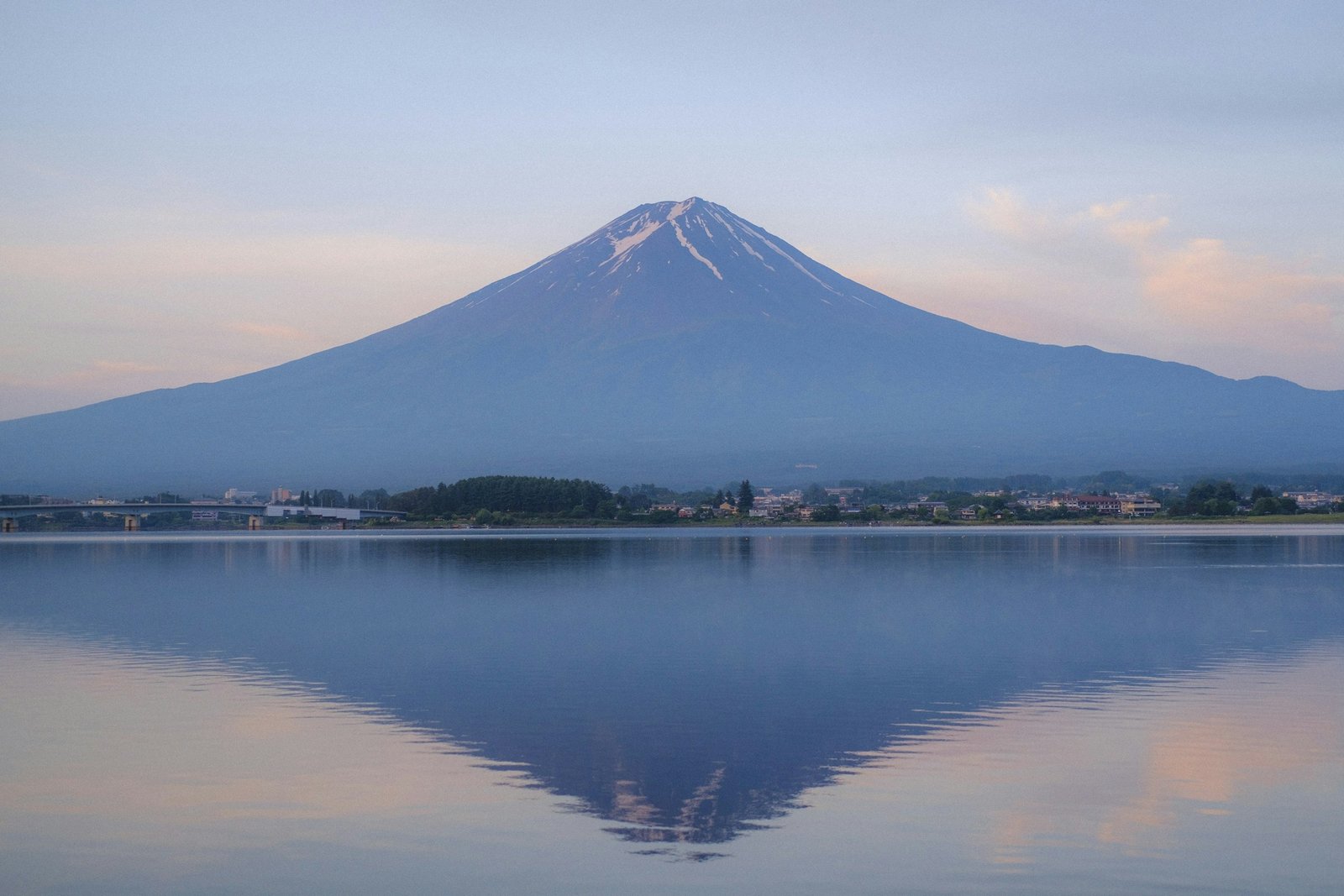 Mount Fuji rising over a calm lake at sunset