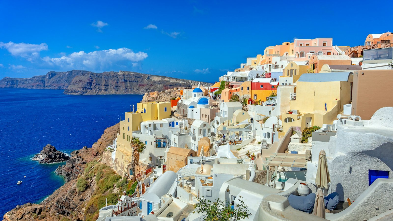 The white hillside homes of Santorini above a calm blue sea